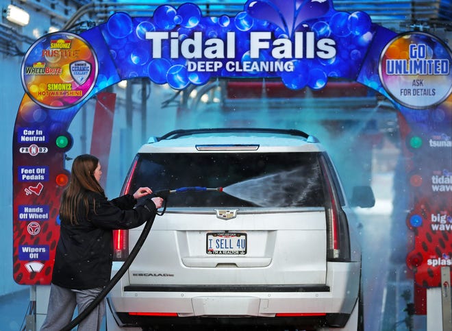 Splash Car Wash worker Kaylee Riggins gives a car a pre-rinse as it makes its way through in Fairlawn.