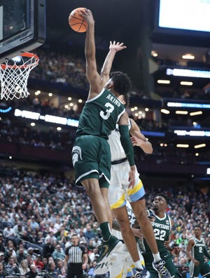 Michigan State Spartans guard Jaden Akins scores and draws the foul against Marquette Golden Eagles forward Oso Ighodaro during the first half in the second round of the NCAA tournament Sunday, March 19, 2023 in Columbus, Ohio.