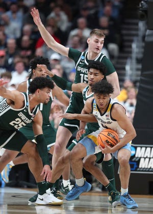 Michigan State Spartans defenders trap Marquette Golden Eagles guard Stevie Mitchell (4) during the first half in the second round of the NCAA tournament Sunday, March 19, 2023 in Columbus, Ohio.