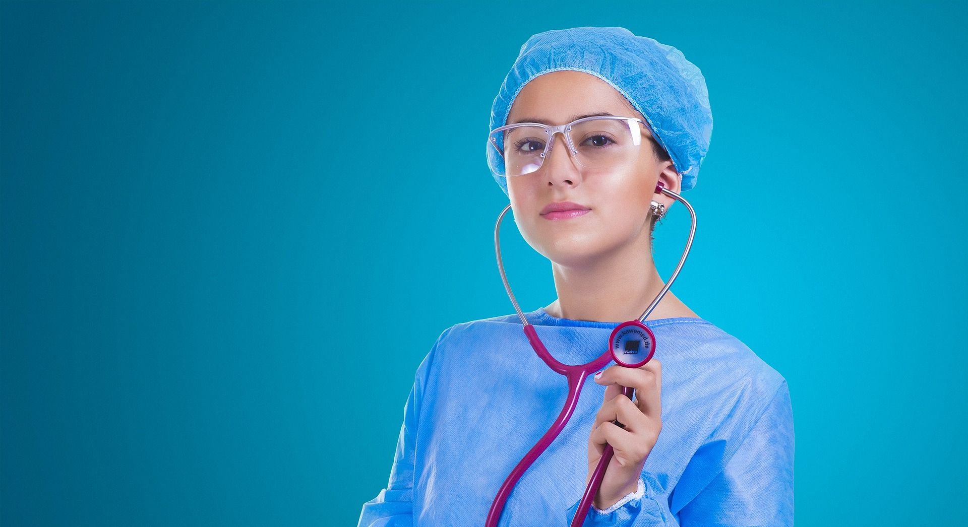 doctor with visor glasses in scrubs holding stethoscope